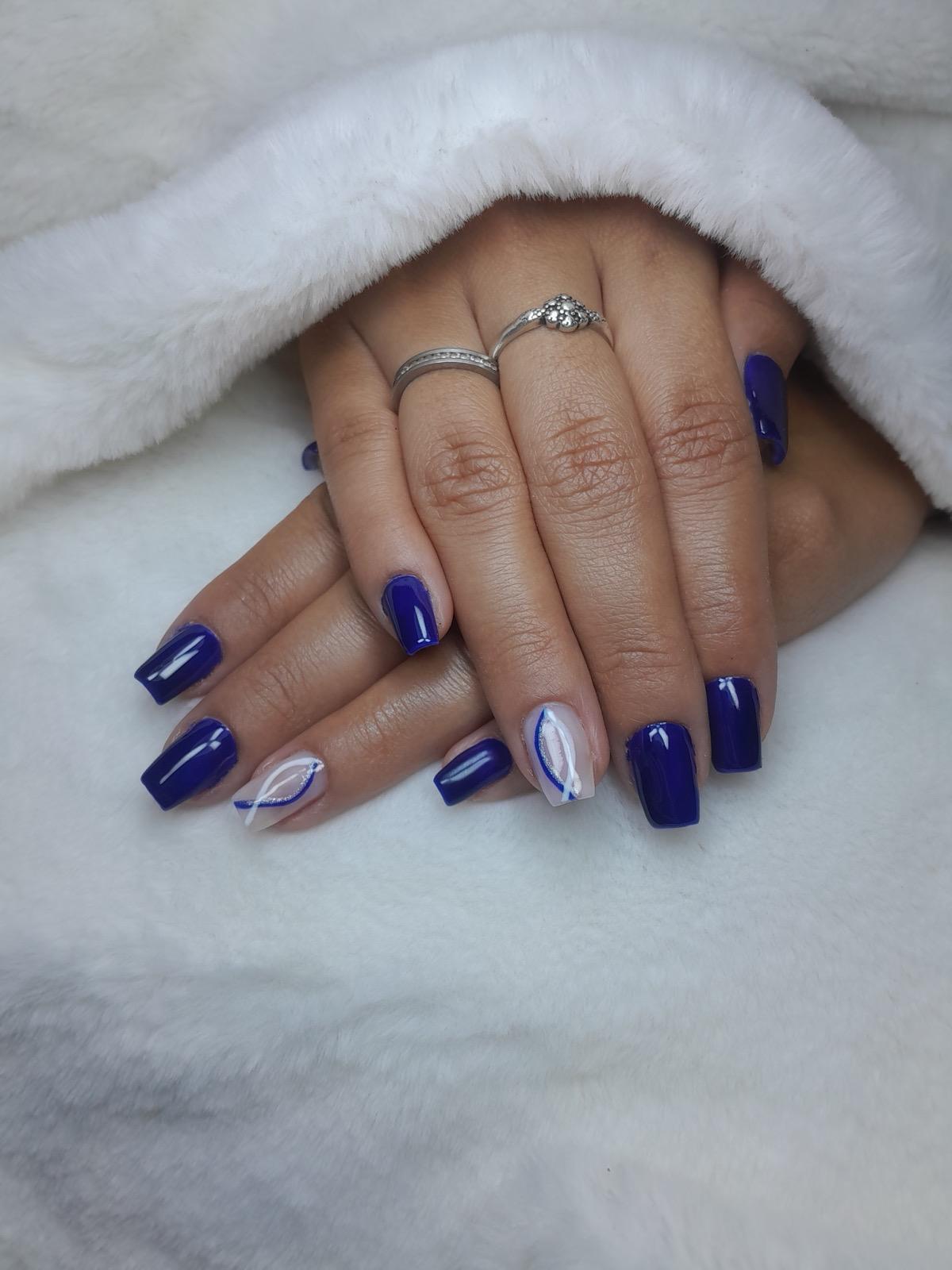 Banho de gel com esmalte azul intenso e detalhes brancos e prateados