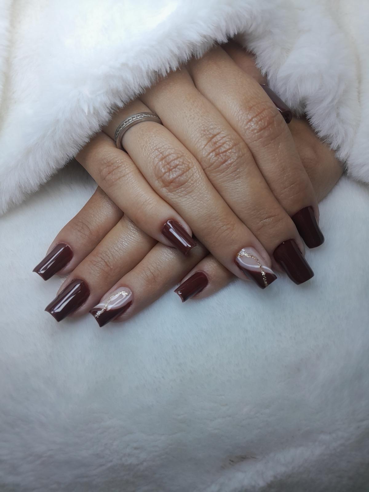 Esmaltação em gel na cor vinho com detalhes delicados brancos e dourados